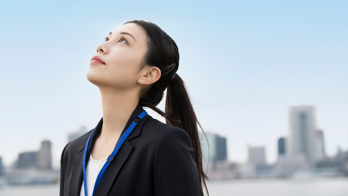 見上げるスーツ姿の女性